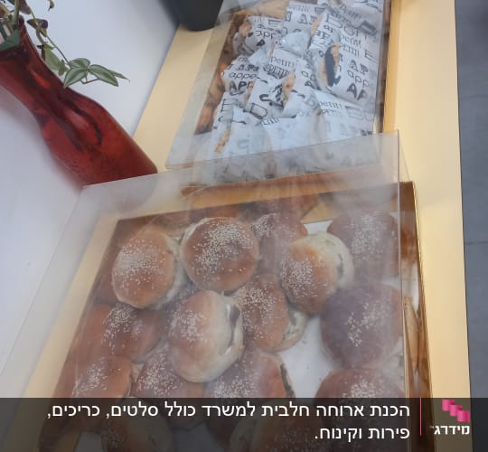 מגש לחמניות שומשום ועטיפות נייר על שולחן קייטרינג